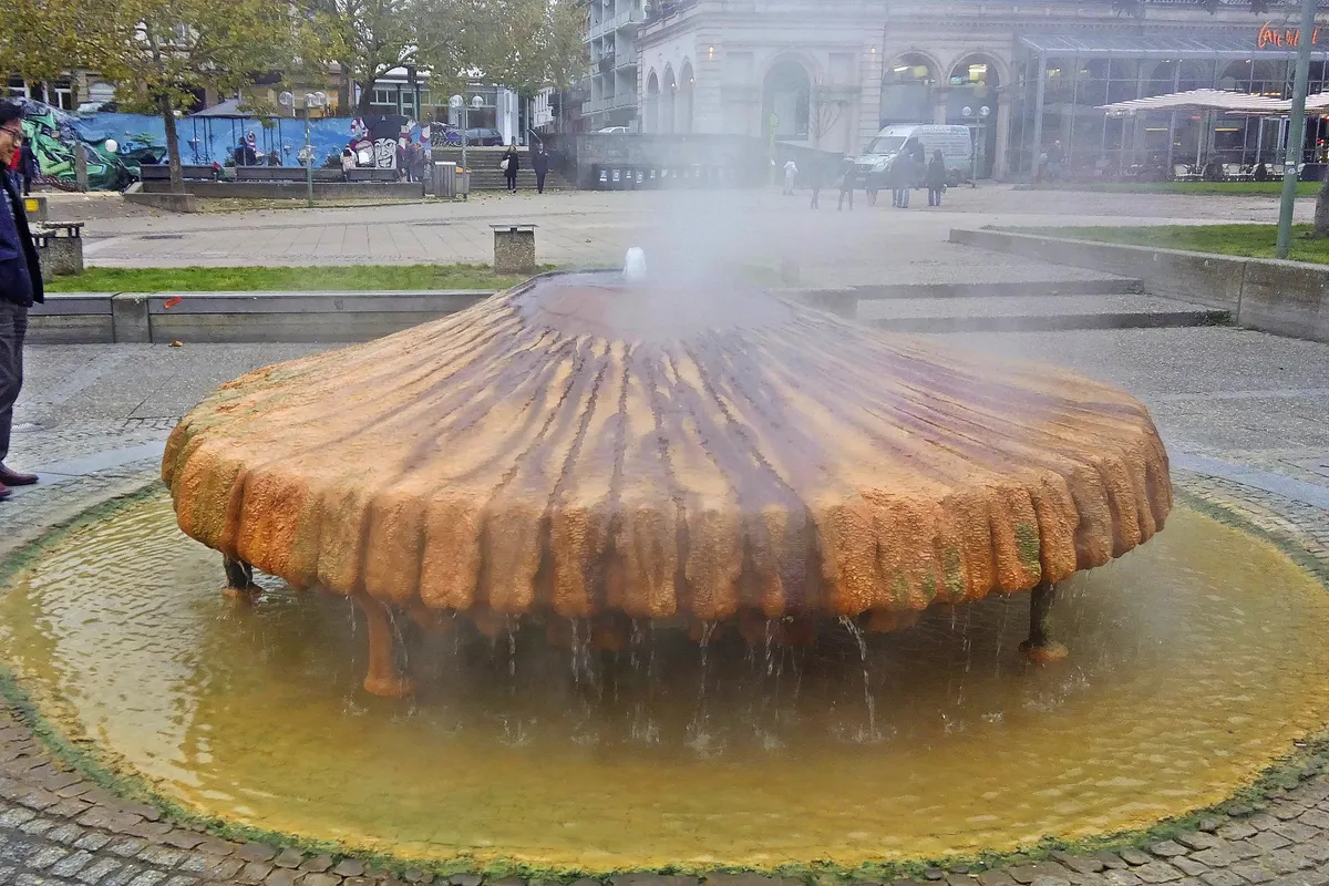 Der dampfende Kochbrunnen mit seiner Sinterschale über dem Becken